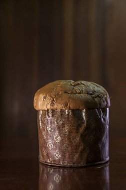 Panettone on the wooden table with textured brown woody background. Panettone concept. Space for text. Christmas concept.	