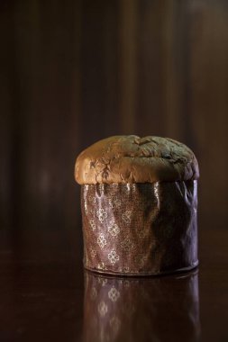 Panettone on the wooden table with textured brown woody background. Panettone concept. Space for text. Christmas concept.	