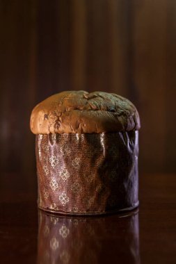 Panettone on the wooden table with textured brown woody background. Panettone concept. Space for text. Christmas concept.	
