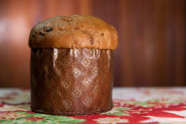 Panettone on the table with a Christmas tablecloth. Panettone concept. Christmas concept. copy space.	