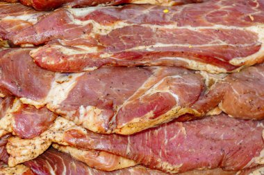 Baharat ve otlarla marine edilmiş, et dokusu olarak bir araya getirilmiş, ızgara veya pişirmeye hazır çiğ domuz dilimleri yakın plan..