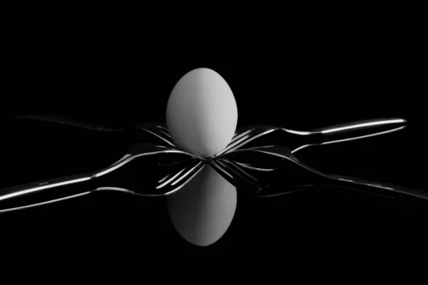 Egg Balancing Four Forks Reflection Black Background — Stock Photo, Image