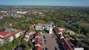 4K aerial footage of Putusk, Poland, featuring the longest market square in Europe dating back to the 16th century. The historic town center includes a medieval tower, church
