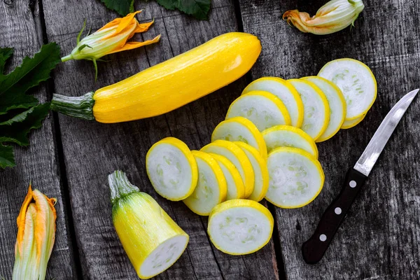 Ahşap masa dilimleri ve kabak çiçekleri ile kabak.