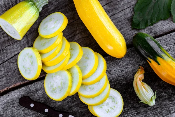 Ahşap masa dilimleri ve kabak çiçekleri ile kabak.