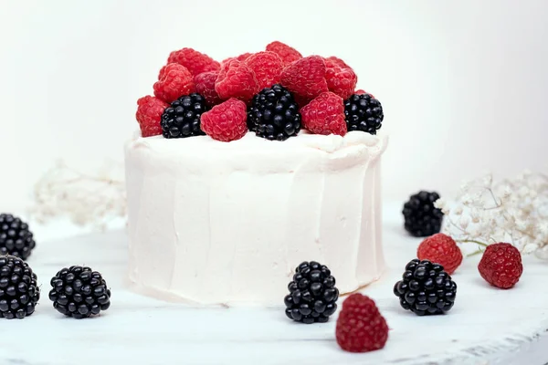 Kek Ahududu ve böğürtlen Beyaz ahşap zemin üzerinde. 