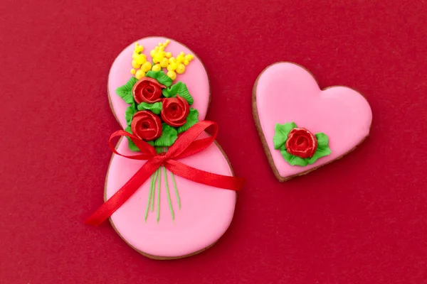 Kadınlar Günü, 8 Mart, figür sekiz, zencefilli çörek, kırmızı arka planda çiçekler. Kart Kadınlar Günü. 