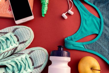 Kırmızı bir arka plan düz spor için aksesuarlar üstten görünüm yatıyordu. Fitness, sağlıklı ve aktif yaşam tarzları. Metin için yer.
