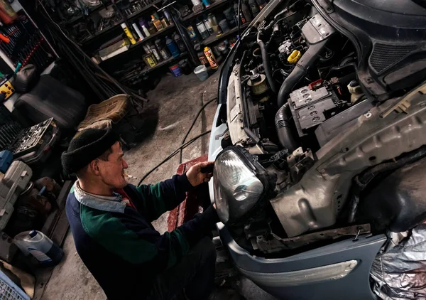 Mecânico com chave de trabalho e reparação de motor de carro na garagem. Pequenas empresas . — Fotografia de Stock