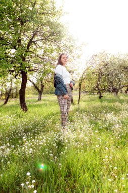 Kahverengi saçlı kız yaz bahçesinde gün batımında uzun saçlı.
