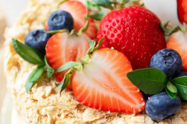 Parlak çilek ve yaban mersinli ballı pasta. Doğum günü için parti pastaları, düğün. Yakın çekim, makro.