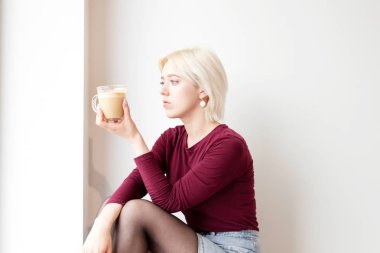 Genç ve çekici sarışın. Sabahları bir fincan kahveye bakıyor..