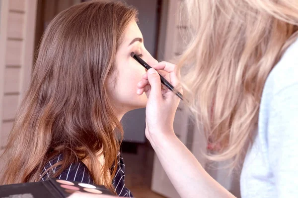 Maquillaje artista pintura hermosa chica sombras de ojos. —  Fotos de Stock