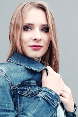 Gri arka planda profesyonel makyajlı güzel bir genç kız. Vzhazhist, moda, kozmetoloji kavramları.