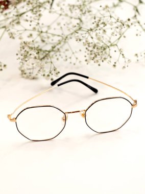 Beyaz çiçekli beyaz arka planda kadın gözlükleri. Optik mağaza, gözlerinizi korumak.