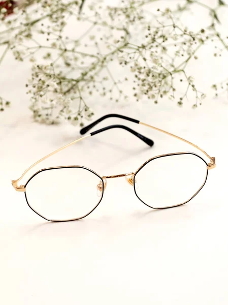 Gafas de mujer sobre fondo blanco con flores blancas. Tienda de óptica, proteja sus ojos . —  Fotos de Stock