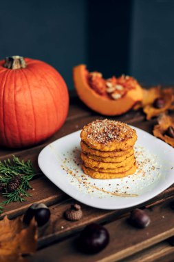 Sonbahar süslemeli bir tabakta bir yığın lezzetli balkabağı gözlemesi.