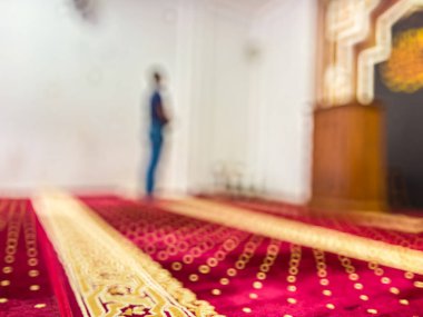 Kırmızı halıda dua eden Müslümanın bulanık görüntüsü