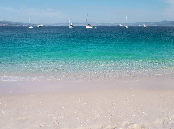 ターコイズブルーの海と白い砂浜ロダス島のビーチ ガリシア スペイン クリスタルクリア浅い水とボート — ストック写真