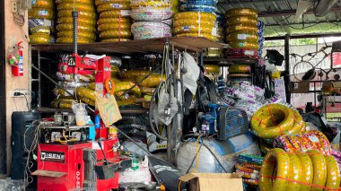 Thailand, Phuket  September 18, 2025: A small motorcycle repair shop with a variety of parts and tires, specializing in scooter repairs. Local transportation service.