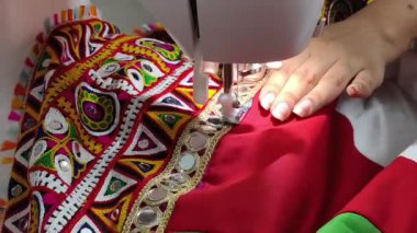 Renkli ayna işi işlemeli dantelin dikiş makinesiyle dikilip Navratri Chaniya Choli için geleneksel Hint tekstil sanatının sergilendiği bir lehenga. Gujarati takımı hazırlanıyor..