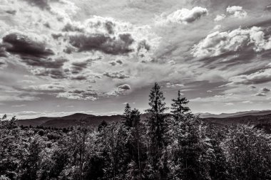 Dağların üzerinde siyah beyaz bulutlar