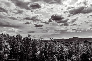 Dağların üzerinde siyah beyaz bulutlar