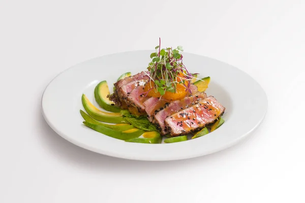 Ton balığı tataki - narenciye sosu, wasabi ve ince avokado dilimleri ile servis edilen susam tohumlu ızgara ton balığı..