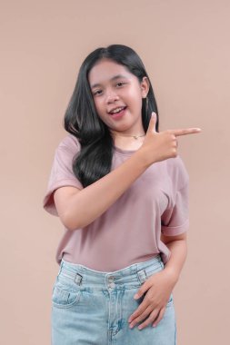 Gündelik kıyafetli Asyalı bir kadın neşeli bir şekilde gülümserken aynı zamanda kendine güveni olan, modern yaşam tarzı kavramları için pozitif enerji ve cazibe gösteren bir kadın..