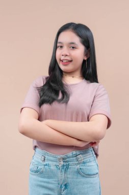 Uzun siyah saçlı, sıradan bir tişört ve kot pantolon giyen, kolları çapraz gülümseyen, özgüvenini ve modern genç yaşam tarzını ifade eden Asyalı bir kadın..