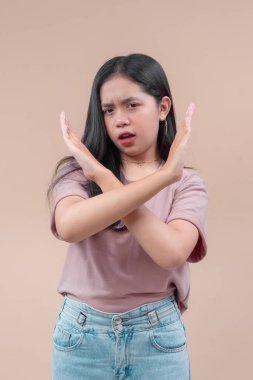 Uzun siyah saçlı Asyalı bir kadın kollarını kavuşturuyor, ciddi yüz ifadesi gösteriyor, reddedilmeyi, reddedilmeyi ve modern kendine güveni simgeliyor..