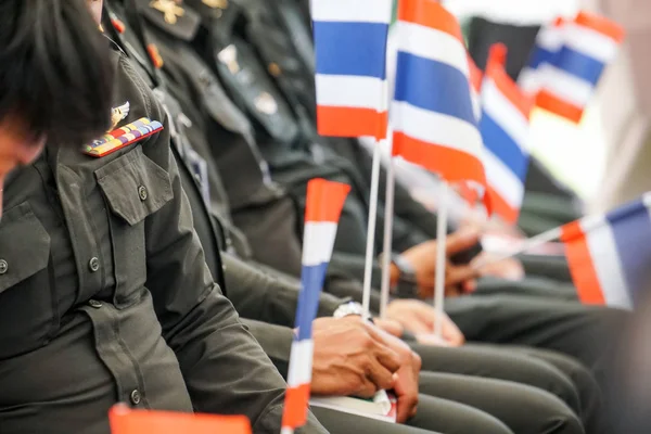 thai soldiers army in green uniform sit and hold thailand flag
