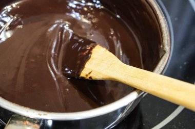 soba üzerinde bir tencerede erime çikolata karıştırılı