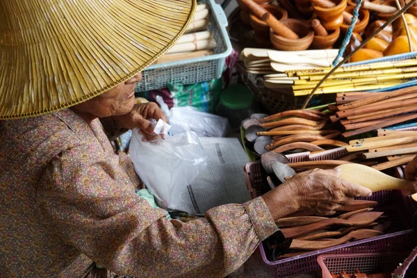 elder woman sell thai traditional cooking utensils