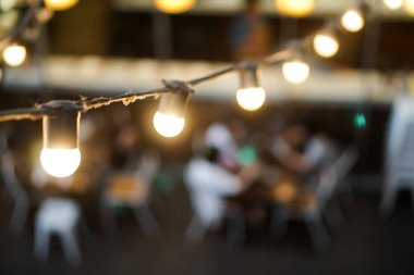 ampul tel açık restoran üzerinde asılı insanlar arka plan bulanık