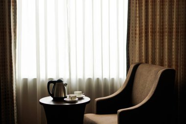 beyaz çay fincan kahve Kupası otel odada bir kanepe koltuk tarafından masaya su ısıtıcısı