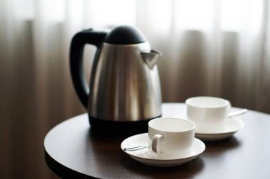 beyaz çay fincan kahve Kupası otel odada bir kanepe koltuk tarafından masaya su ısıtıcısı