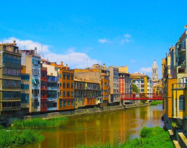 Sarı ve turuncu renkli evleri su nehir, Girona, Catalonia, İspanya yansıtılır. Kilise Saint Mary Katedrali, arka plan