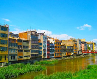 Girona, Catalonia, İspanya su Nehri'nde yansıyan renkli sarı ve turuncu evleri.
