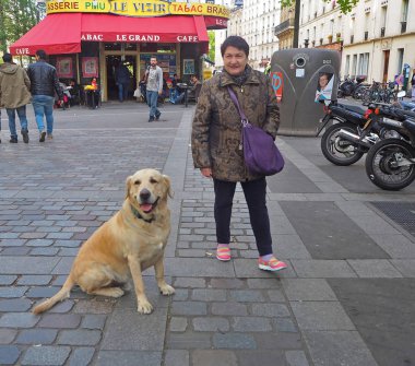 Paris, Fransa - Nisan 2017: Labrador Retriever köpek Montmartre sokak metro yakınındaki kadınla
