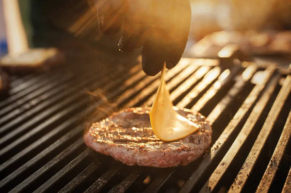 Sığır eti burger peynir ile açık mutfak açık yapma Şef. Sokak lokanta. Günbatımı ışık.