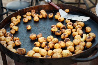 Büyük bir tavada genç bir patates. Dışarıda kavrulmuş.
