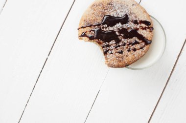 Krema ve şeker tozu ile ısırıldı bisküvi. Üstten görünüm. Beyaz ahşap masa.