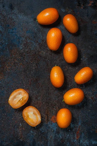 Kumquat-Früchte auf schwarzem Keramikteller auf dunklem Hintergrund — Stockfoto