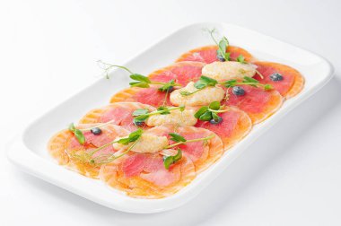 İnce dilimlenmiş somon pike havyar ve microgreen. Bir beyaz plaka ve beyaz arka plan üzerinde.