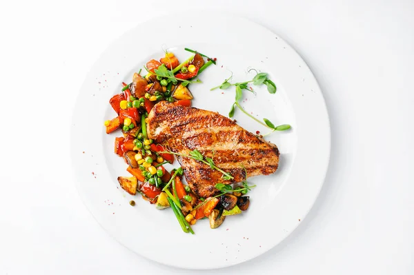 Kızarmış parça et beyaz plaka ve beyaz arka plan üzerinde sebze salatası ile