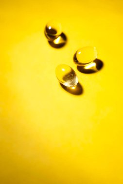 Hapları Sarı zemin üzerine sarı şeffaf balık yağı. Dikey görüntü