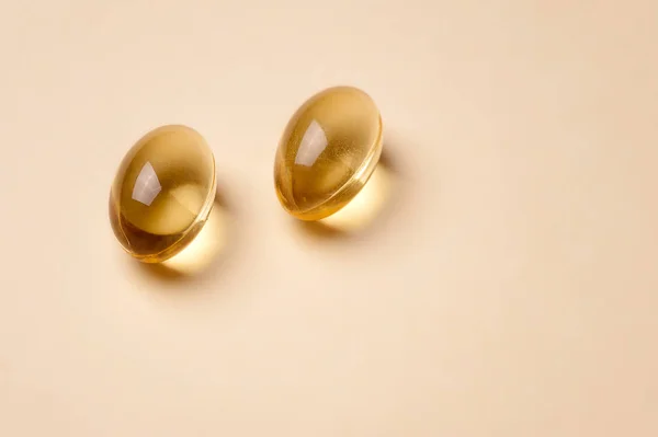 Hapları bej renkli arka plan üzerinde sarı şeffaf balık yağı