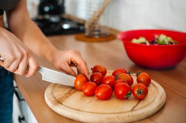 keskin bıçakla el kesme domates kesme tahtası üzerinde kapat