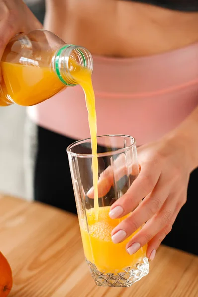 Kobieta w dres wylewanie soku pomarańczowego — Zdjęcie stockowe